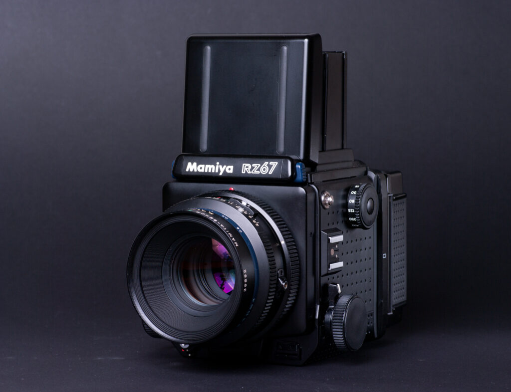 Mamiya RZ67 in black with opened waistlevel finder in front of dark-grey background