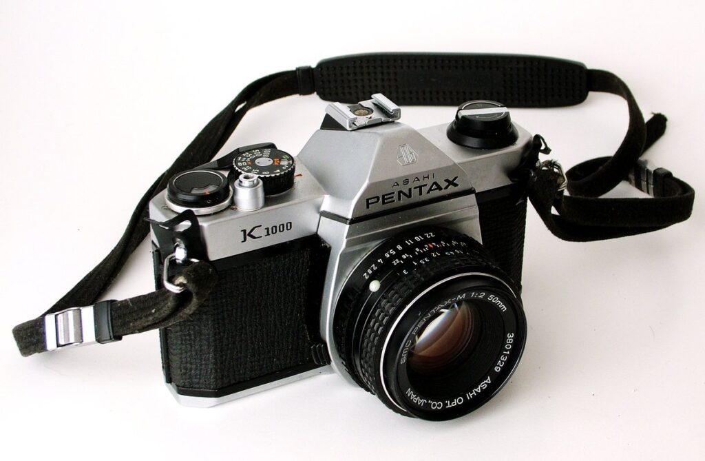 Pentax K1000 silver analog film camera with neckstrap